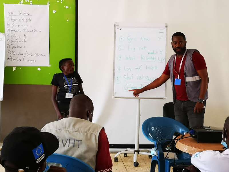 Brian Ssennoga training Village Health Teams — community health technology